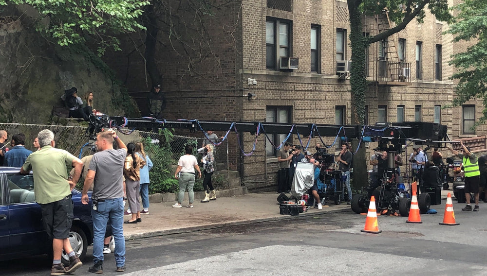 A film crew operating cameras and a crane on a Washington Heights street.