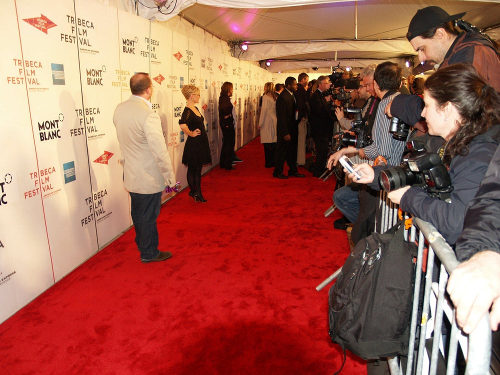 Press photographers and guests on the Tribeca Film Festival red carpet.